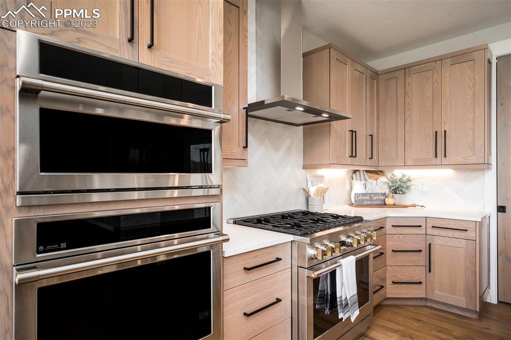 3397 Bark Tree Trail Colorado Springs, CO 80921 - Photo 13 of 50 a kitchen with stainless steel appliances a stove microwave and cabinets