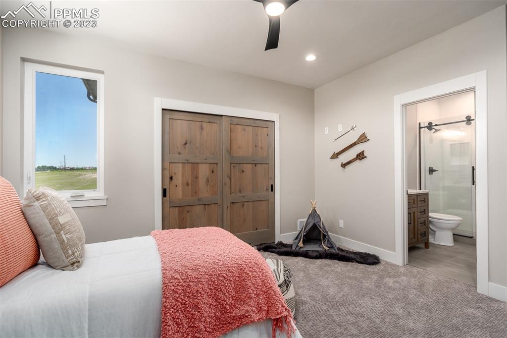 3397 Bark Tree Trail Colorado Springs, CO 80921 - Photo 22 of 50 a bedroom with a bed and a chandelier