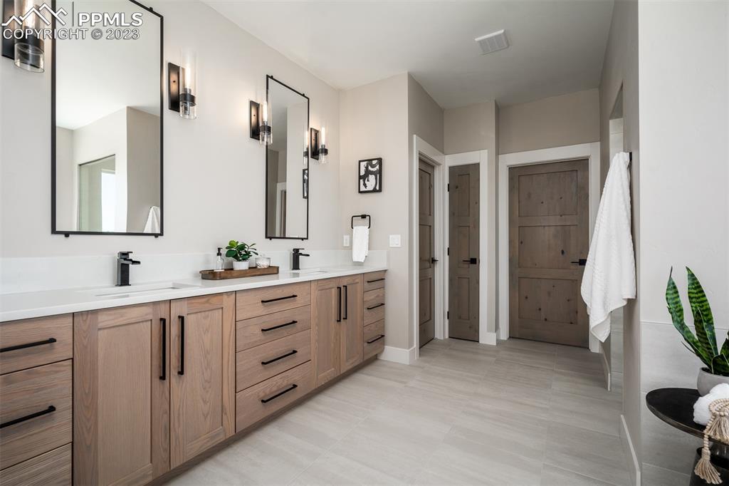 3397 Bark Tree Trail Colorado Springs, CO 80921 - Photo 29 of 50 a spacious bathroom with a double vanity sink a mirror and a shower