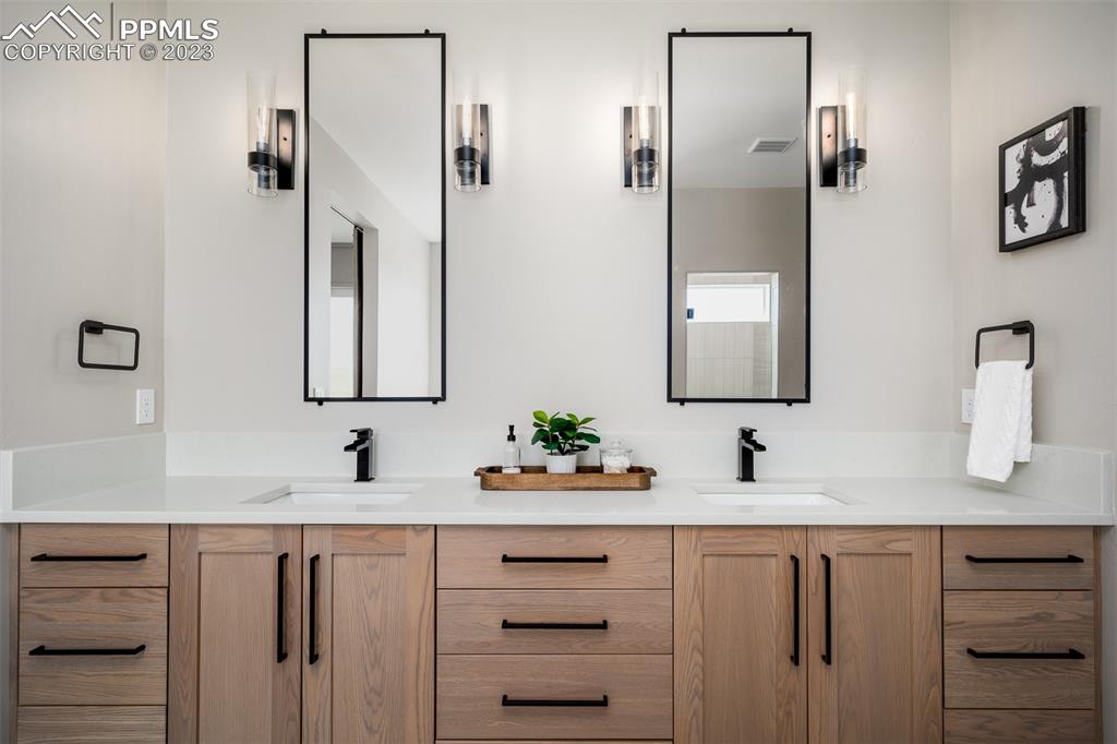 3397 Bark Tree Trail Colorado Springs, CO 80921 - Photo 31 of 50 a bathroom with double vanity sink two mirror and window