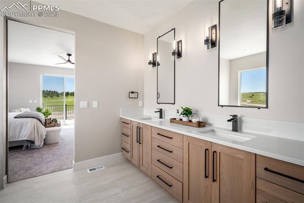 3397 Bark Tree Trail Colorado Springs, CO 80921 - Photo 32 of 50 a bathroom with a double vanity sink mirror and window