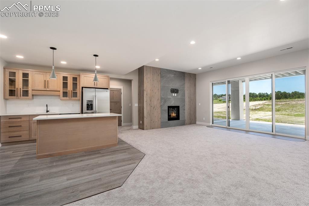 3397 Bark Tree Trail Colorado Springs, CO 80921 - Photo 38 of 50 a large kitchen with stainless steel appliances kitchen island granite countertop a refrigerator and a sink