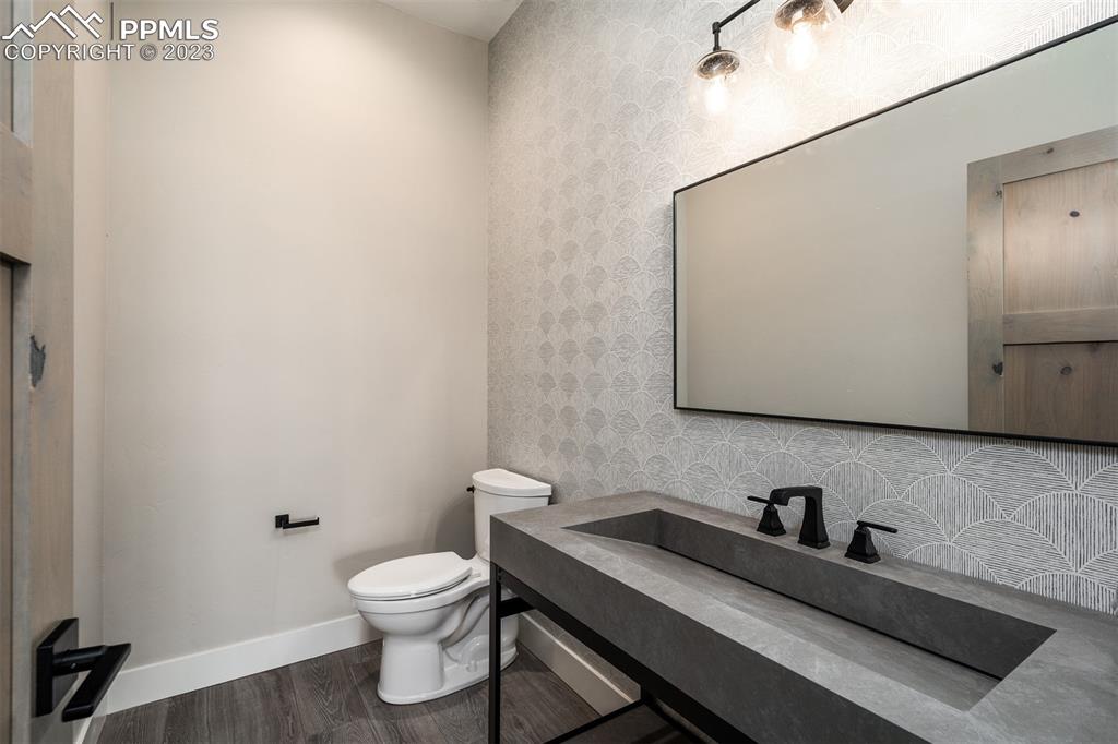 3397 Bark Tree Trail Colorado Springs, CO 80921 - Photo 40 of 50 a bathroom with a granite countertop toilet a sink and a mirror