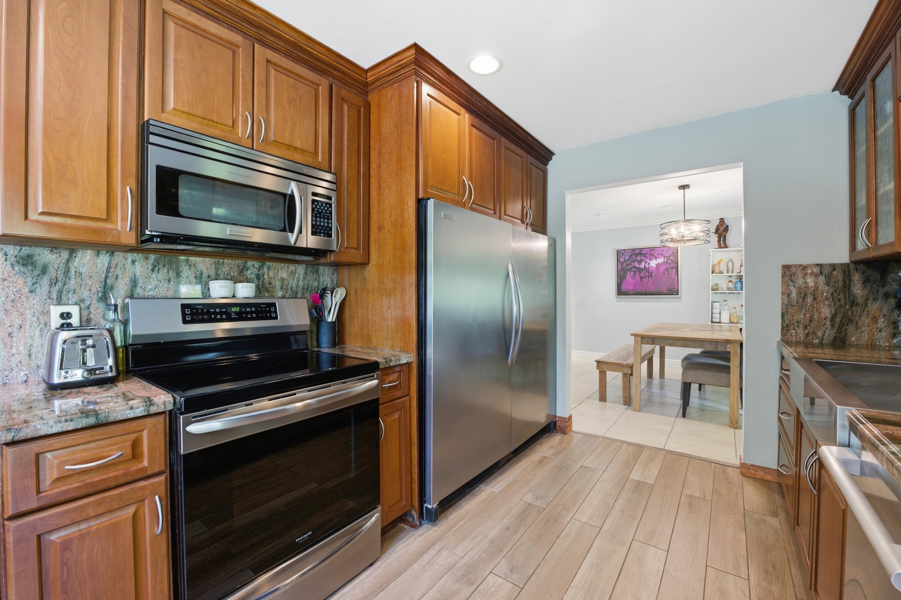 22504 Southwest 65th Avenue Boca Raton, FL 33428 - Photo 13 of 36 a kitchen with stainless steel appliances and wooden cabinets