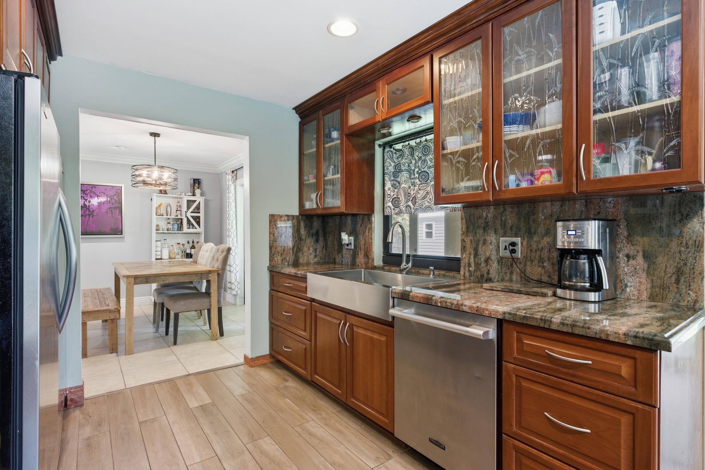 22504 Southwest 65th Avenue Boca Raton, FL 33428 - Photo 14 of 36 a kitchen with stainless steel appliances granite countertop a stove and cabinets