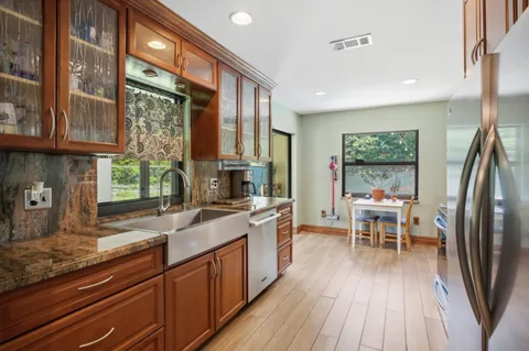 a kitchen with stainless steel appliances granite countertop sink stove top oven and cabinets