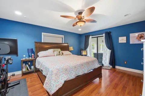 a bedroom with a bed and wooden floor
