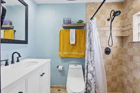 a bathroom with a sink mirror and toilet