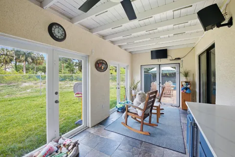 a living room with furniture and a floor to ceiling window