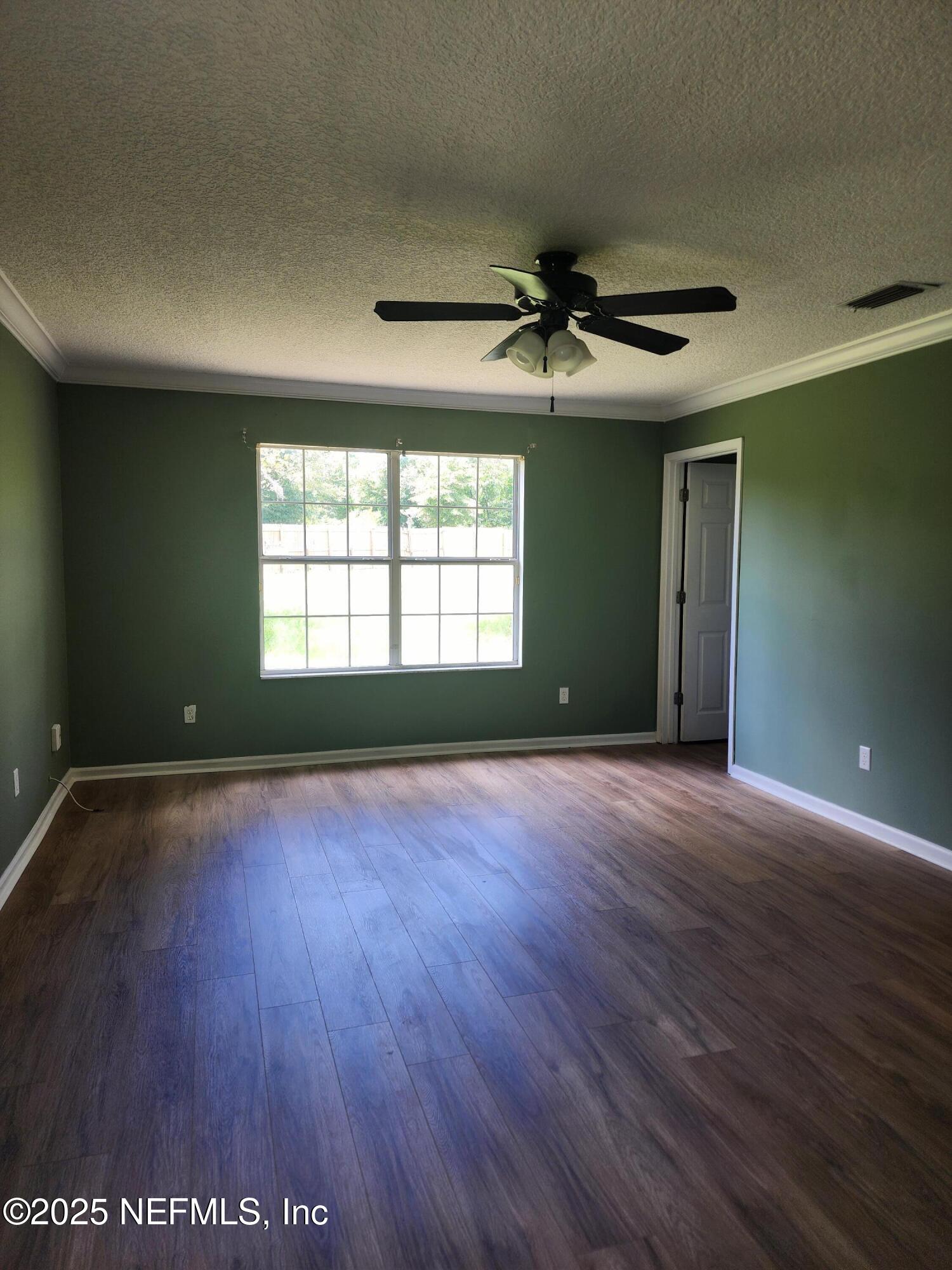 3794 Ron Road Green Cove Springs, FL 32043 - Photo 16 of 34 a view of an empty room with wooden floor and a window