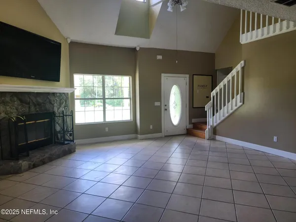 a view of an empty room with a fireplace and a window