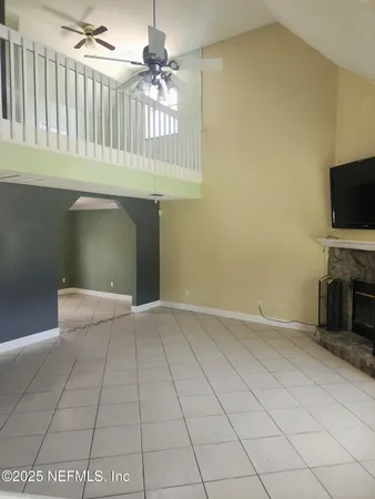 a view of an empty room with a fireplace and a window
