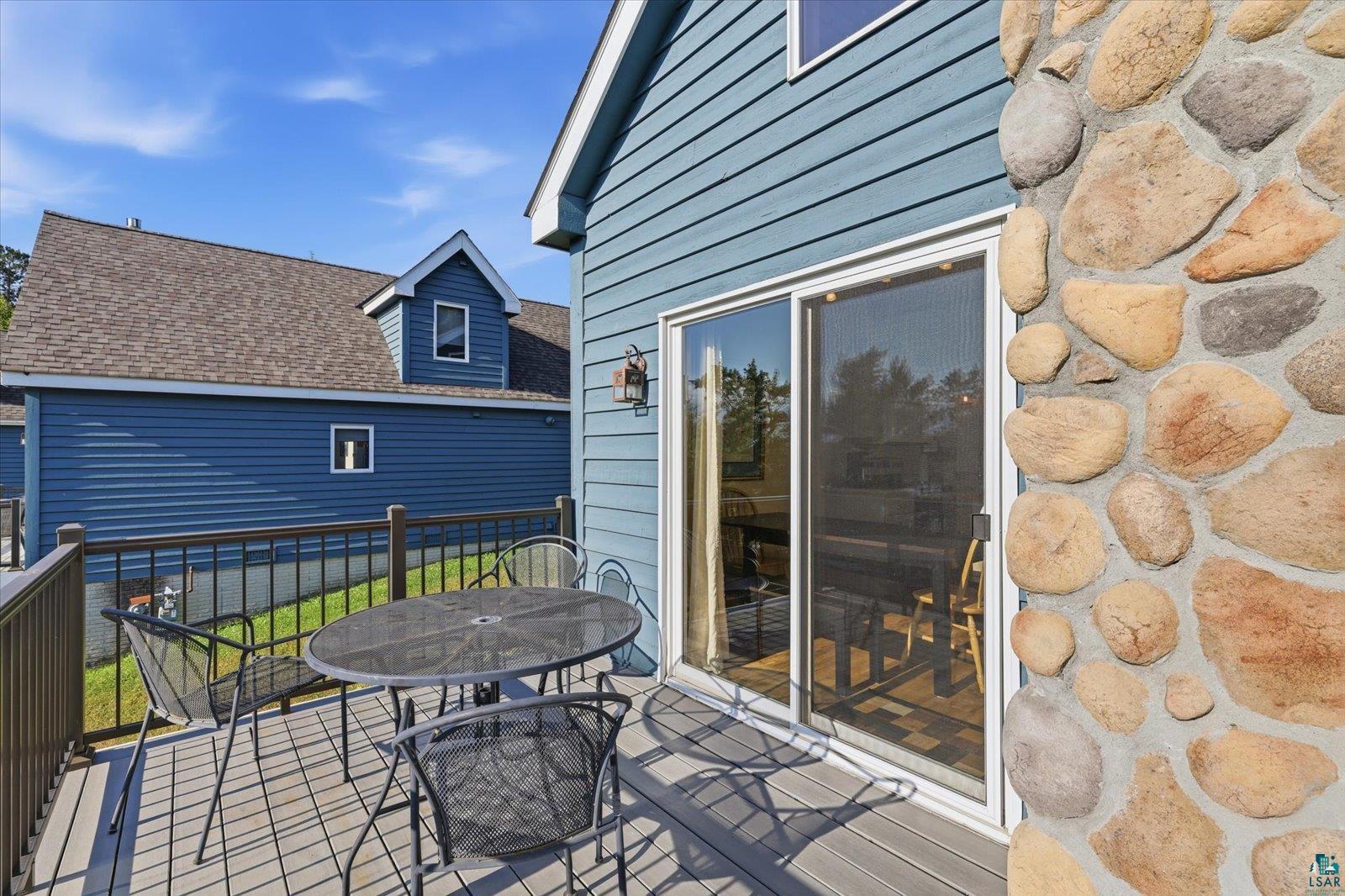 6266 Giants Ridge Road Biwabik, MN 55705 - Photo 20 of 29 Composite deck with dark railings, stone-clad exterior accent, and sliding glass door