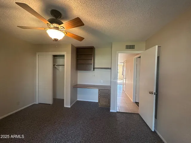 a view of a hallway with a refrigerator and a ceiling fan