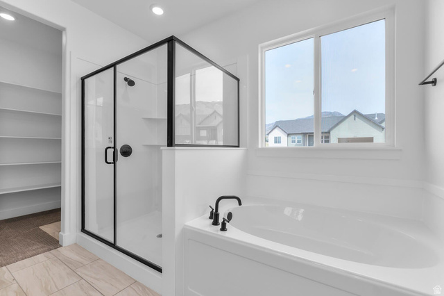 342 North Rhyolite Drive, Unit 88 Hurricane, UT 84737 - Photo 15 of 26 Contemporary bathroom featuring a black-framed glass shower, a deep soaking tub with matte black fixtures, and light-toned tile flooring