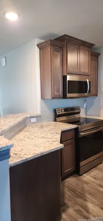 a kitchen with stainless steel appliances granite countertop a stove and a microwave