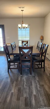a living room with furniture a dining table and a chandelier