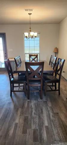 a living room with furniture a dining table and a chandelier