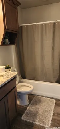 a bathroom with a granite countertop toilet and a sink