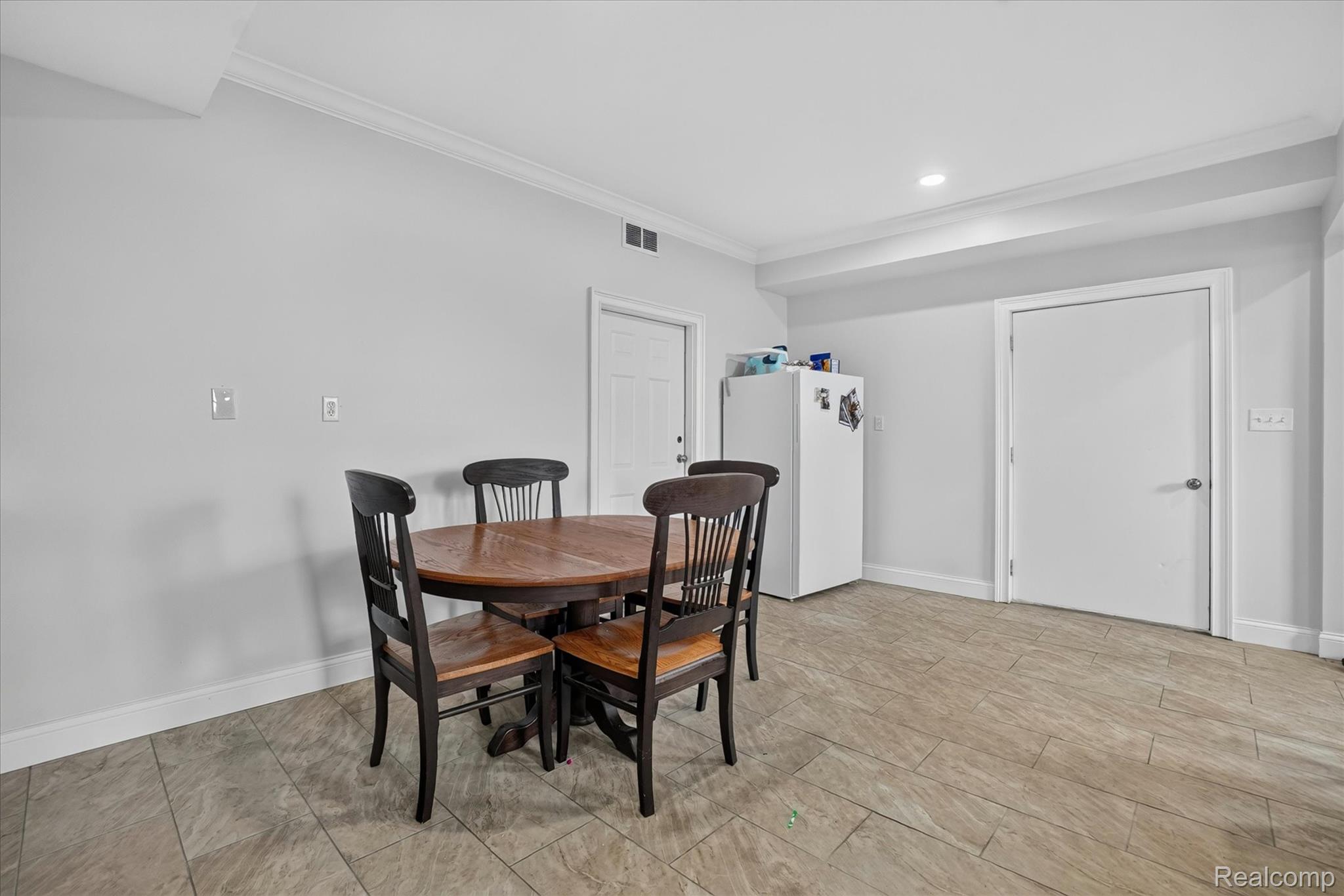 6524 Kelly Road Flushing, MI 48433 - Photo 18 of 47 Spacious room featuring light gray walls, crown molding, and wood-look tile flooring