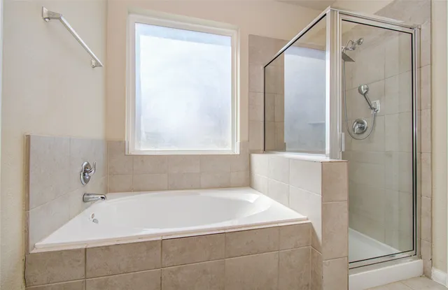 a spacious bathroom with a tub sink and mirror