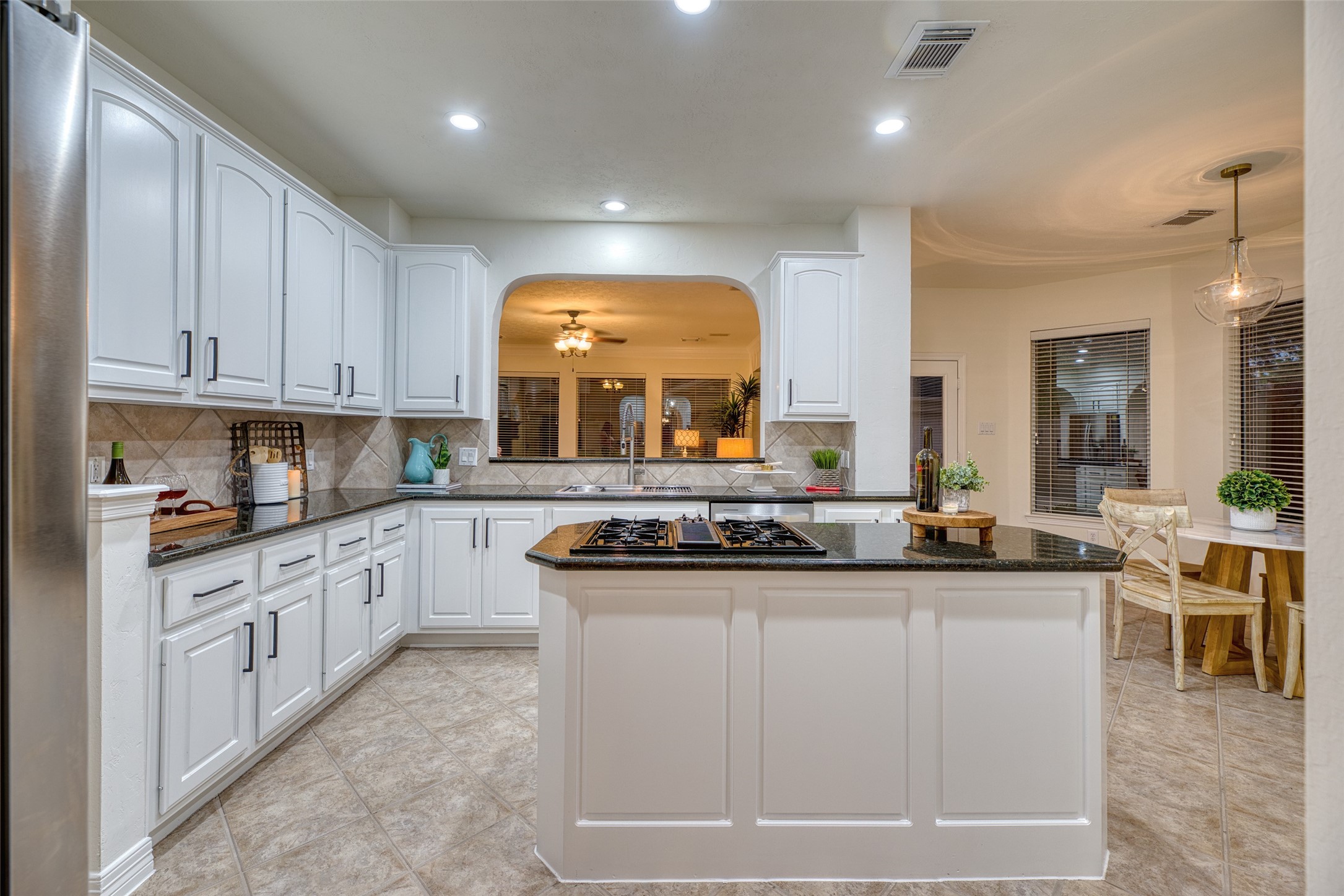 911 Chisel Point Drive Houston, TX 77094 - Photo 13 of 50 Bright kitchen with crisp white cabinetry, granite counters, and stainless steel appliances. Large center island with gas cooktop and abundant storage.