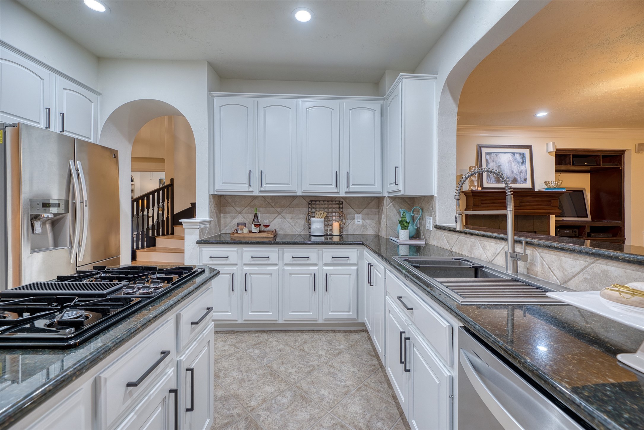911 Chisel Point Drive Houston, TX 77094 - Photo 14 of 50 Functional kitchen layout with granite counters, stainless steel appliances, and an abundance of storage. Gas cooktop and deep sink overlook the living area for easy entertaining.