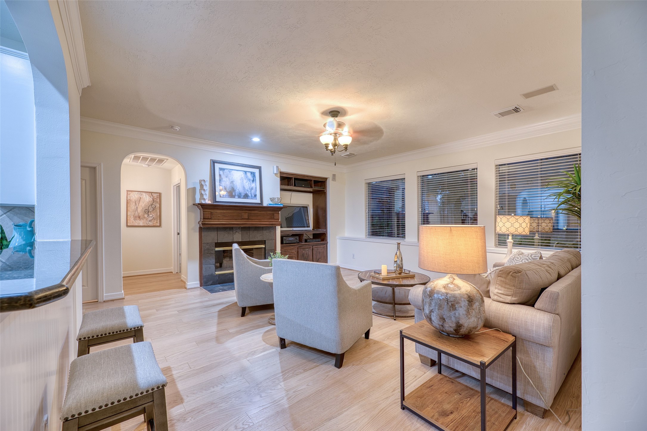 911 Chisel Point Drive Houston, TX 77094 - Photo 16 of 50 Cozy living room featuring a wood-trimmed fireplace, built-in entertainment center, and large windows allowing natural light to fill the space.
