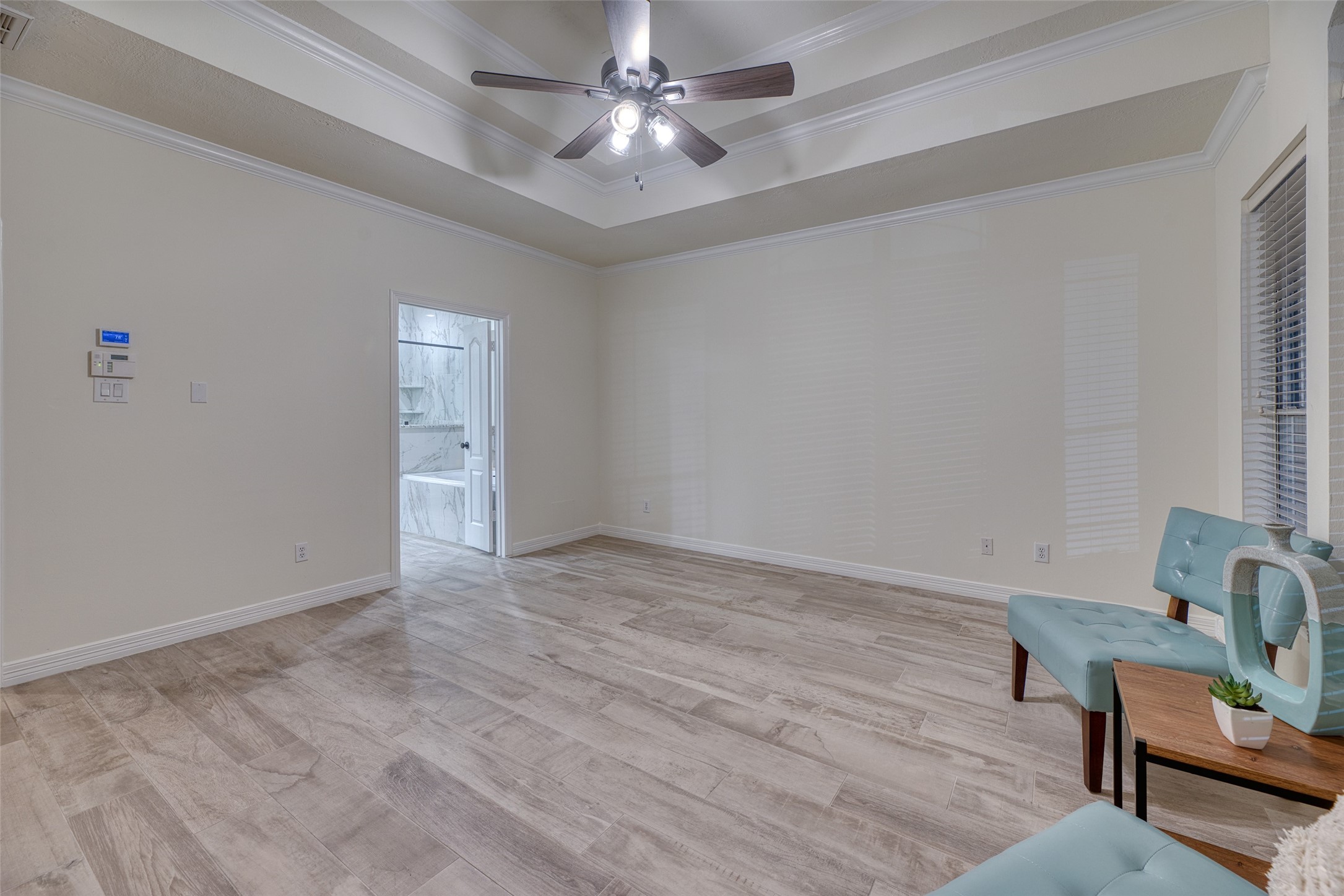 911 Chisel Point Drive Houston, TX 77094 - Photo 21 of 50 Primary bedroom with direct access to a luxurious en-suite bath. Elegant tray ceiling detail and updated flooring complete the retreat-like feel.