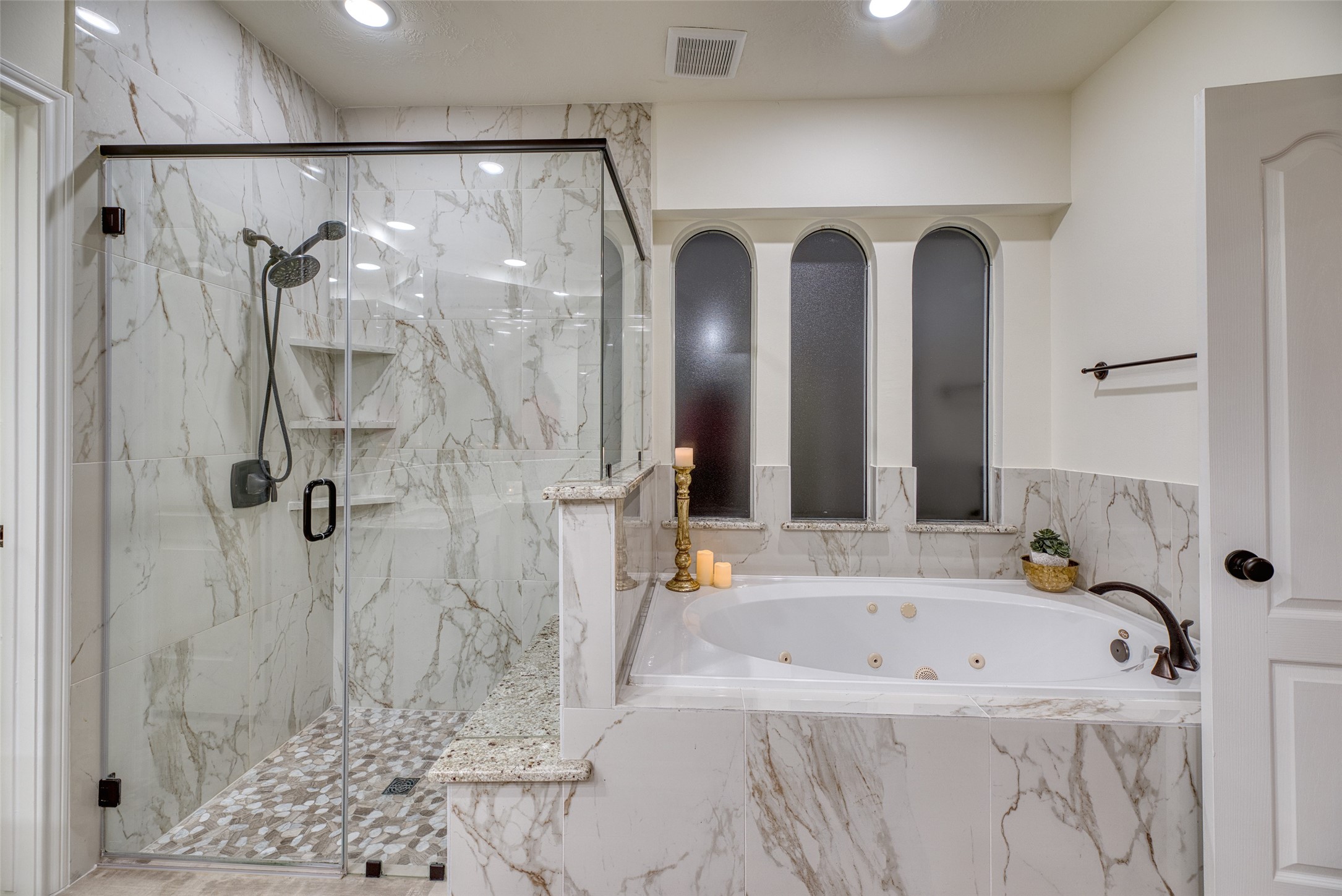911 Chisel Point Drive Houston, TX 77094 - Photo 24 of 50 Beautifully tiled walk-in shower with frameless glass enclosure and rainfall showerhead. Adjacent jetted soaking tub offers the ultimate relaxation retreat.