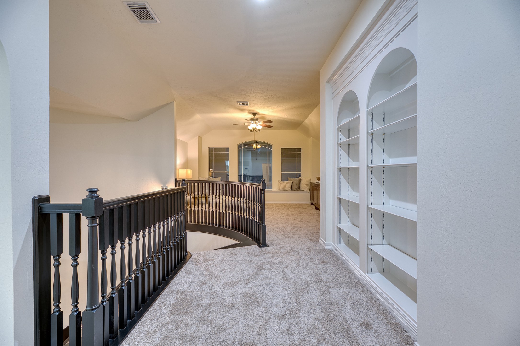 911 Chisel Point Drive Houston, TX 77094 - Photo 32 of 50 Spacious upstairs landing with elegant railing, plush carpet, and custom built-in shelving—perfect for displaying books or décor.