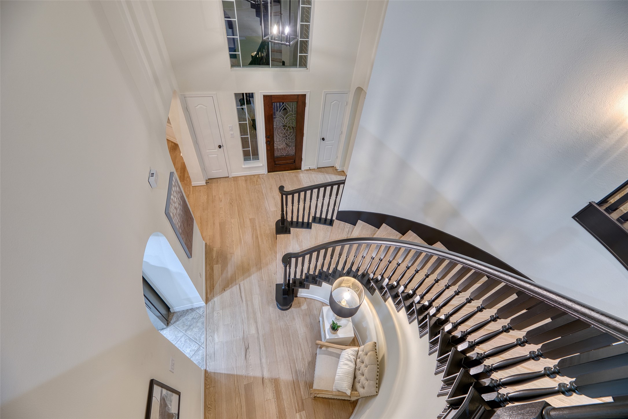 911 Chisel Point Drive Houston, TX 77094 - Photo 38 of 50 A breathtaking view from the upstairs landing captures the sweeping curved staircase, accented with elegant wrought-iron spindles and rich wood tones.