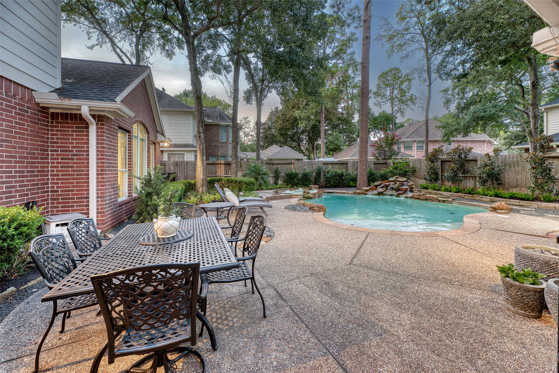 911 Chisel Point Drive Houston, TX 77094 - Photo 42 of 50 Elegant outdoor living at its finest — a spacious stone patio with a decorative wrought iron dining set is perfectly positioned to overlook the sparkling pool.