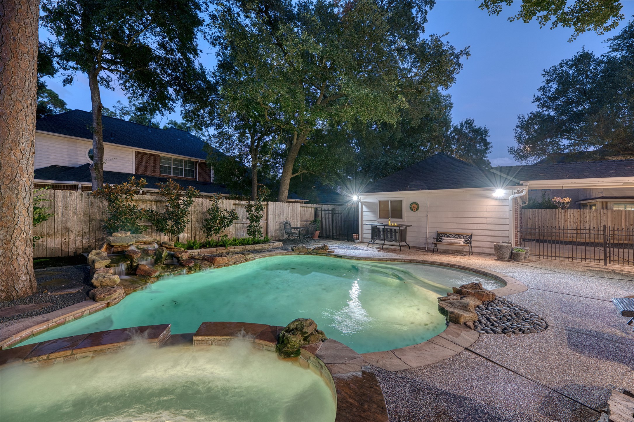 911 Chisel Point Drive Houston, TX 77094 - Photo 47 of 50 This secluded backyard features a glistening pool and spa with a tranquil waterfall feature. The fully fenced yard and mature trees create a private, peaceful setting for both relaxation and gatherings.