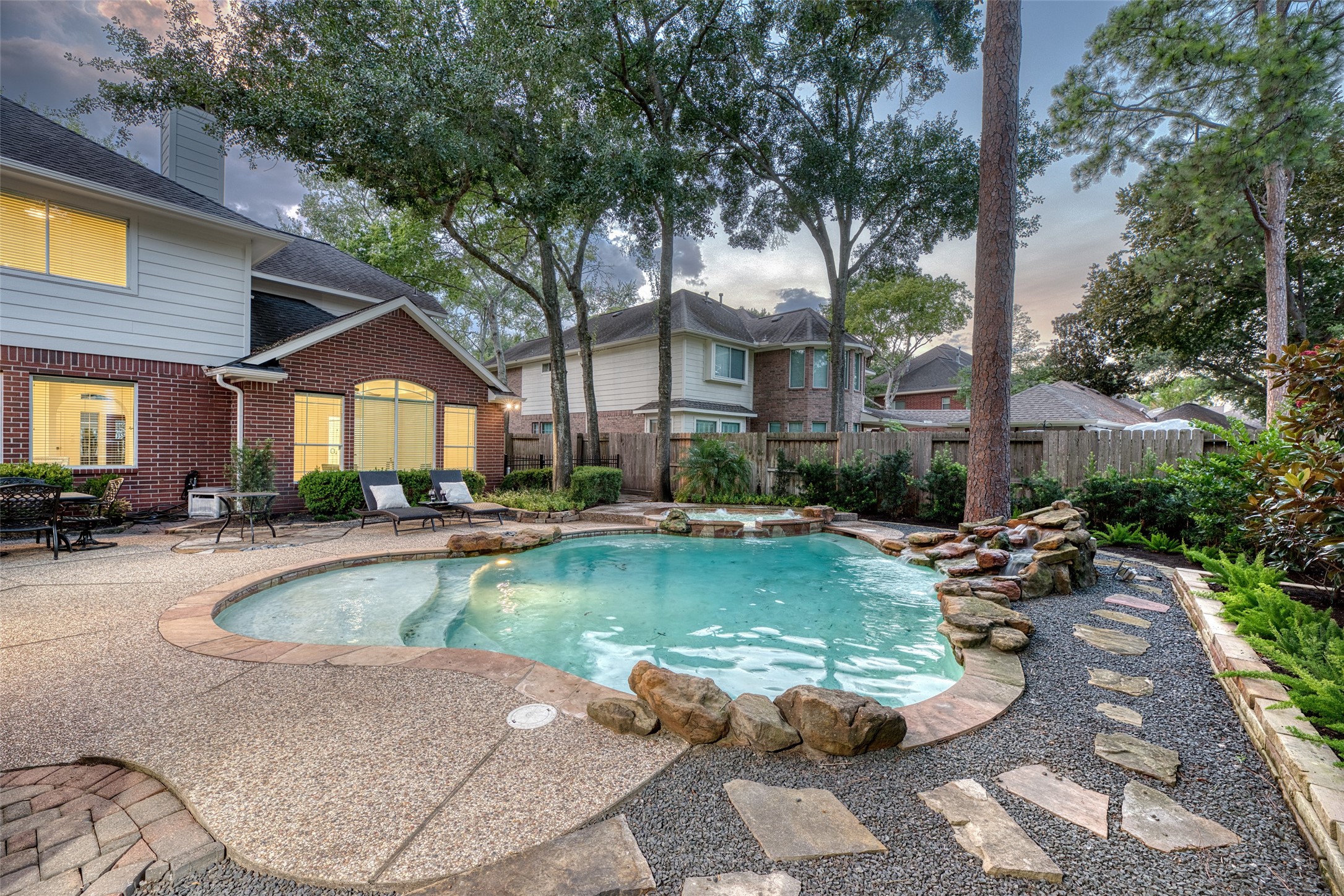 911 Chisel Point Drive Houston, TX 77094 - Photo 49 of 50 This backyard retreat features a stunning freeform pool framed by natural stone, a meandering pebble path, and lush plantings. The surrounding mature trees add shade and character, creating a peaceful oasis just steps from the home.