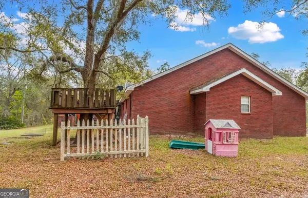 a view of a house with a yard and fence