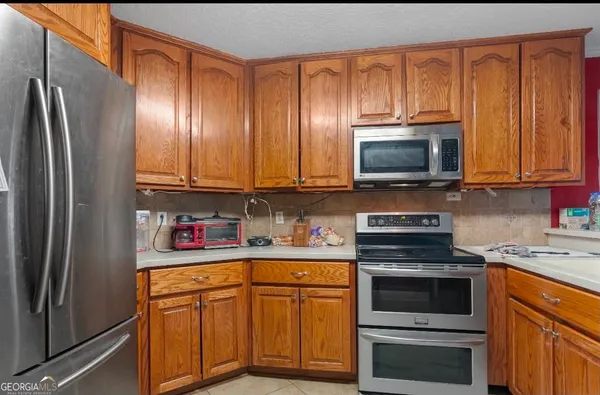 a kitchen with stainless steel appliances granite countertop a refrigerator microwave and sink