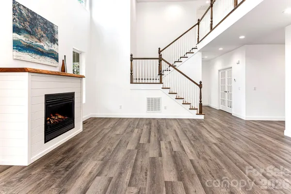 a view of a livingroom with wooden floor and a fireplace