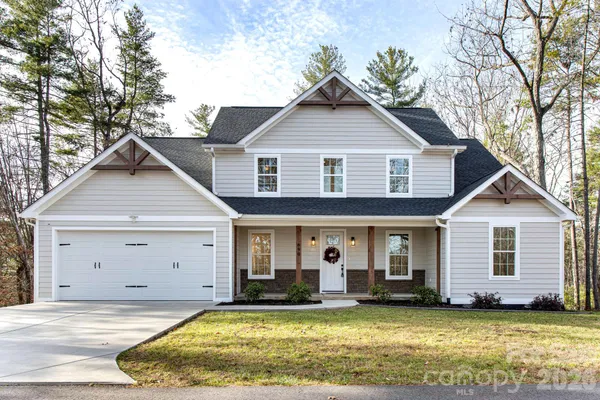 a view of a house with a yard patio and a tree