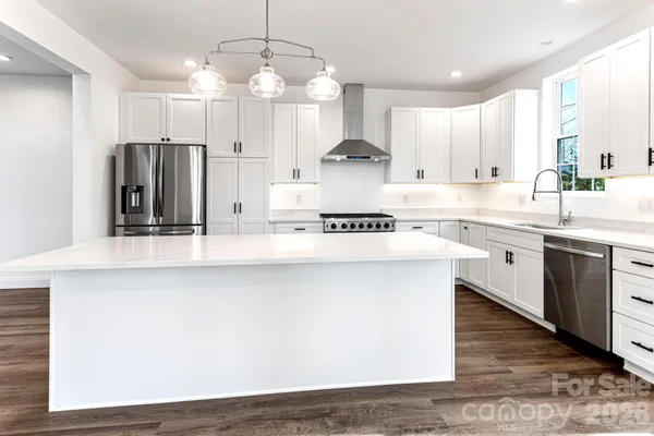 a kitchen with kitchen island granite countertop a sink cabinets and stainless steel appliances