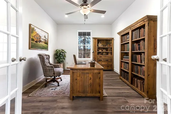 a living room with hard wood floors and a book shelf