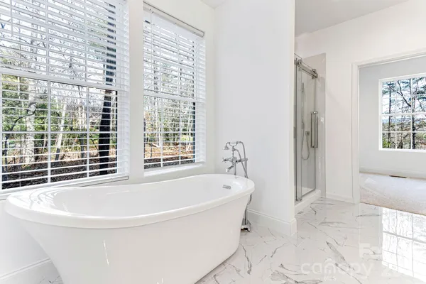 a white bath tub sitting in a bathroom next to a window