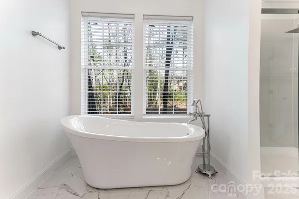 a white bath tub sitting in a bathroom next to a window