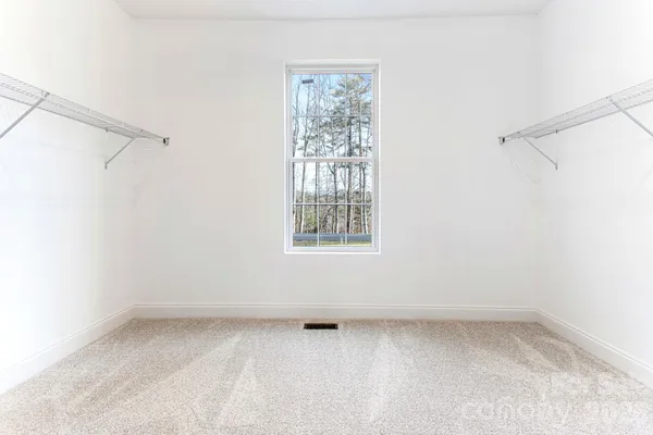 a view of a small space with wooden floor and a window