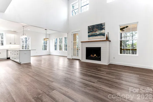 wooden floor fireplace and windows in an empty room
