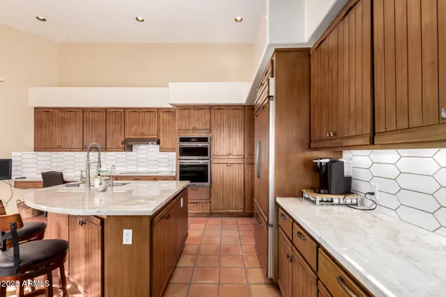 a kitchen with a sink refrigerator and cabinets