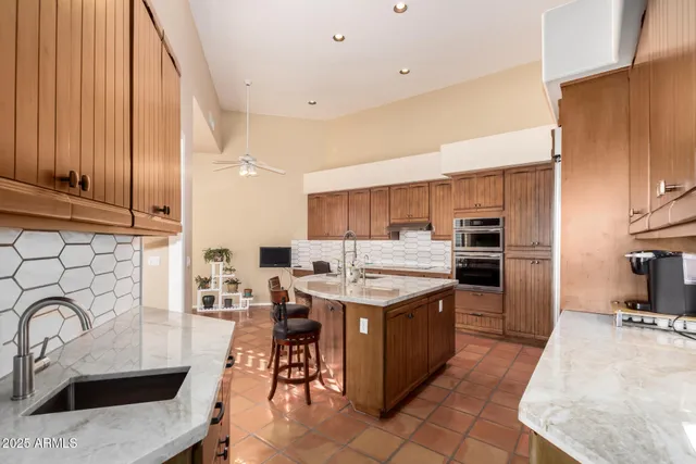 a kitchen with a sink a counter top space stainless steel appliances and cabinets