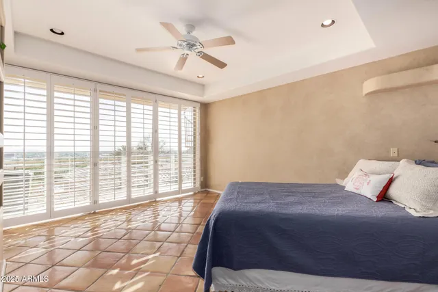 a bedroom with a large bed a flat tv screen and a dresser