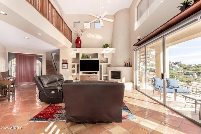 a living room with furniture a flat screen tv and a floor to ceiling window