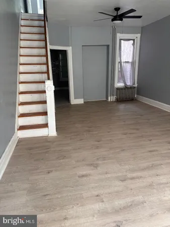a view of a livingroom with wooden floor and stairs